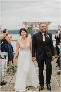 a bride and groom walking towards the camera after they said i do at their semiahmoo resort wedding