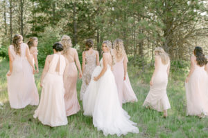 bride and bridesmaids walking away from the camera and the bride is looking back at the camera