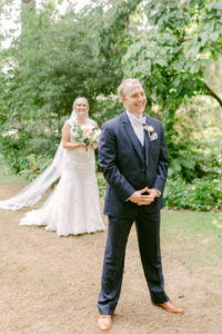 a bride walking up to the groom from behind at lakewold gardens in washington to do their first look pros and cons