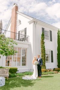a couple standing together outside of their wedding venue at the admiral house in seattle washington