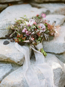 a bride's wedding bouquet sitting on a stone ground