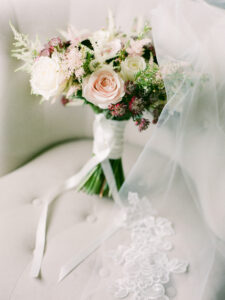 a wedding bouquet on a chair with a lace veil draped over it are wedding traditions