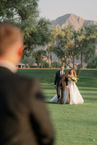 a father giving his daughter away at her palm springs wedding on a golf course