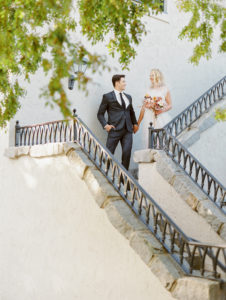 a bride and groom standing at the top of some stairs