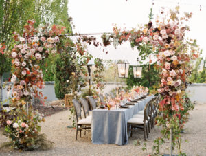 a long wedding reception table with florals and candles on it at the hotel domestique 