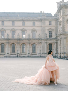 a woman in a puffy pink dress at the louvre in paris