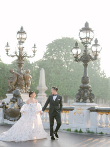 a bride and groom holding hands and walking towards to camera in paris france