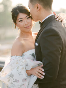 a woman looking at the camera while a man kisses her temple on point alexandre bridge in paris france
