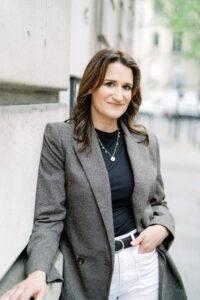 a woman with brown hair leaning up against a wall in paris france