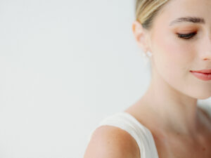 a close up of a woman looking down in a wedding grown