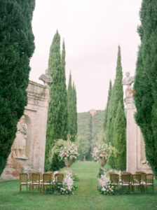 a wedding ceremony set up in the gardens of villa cetinale in italy