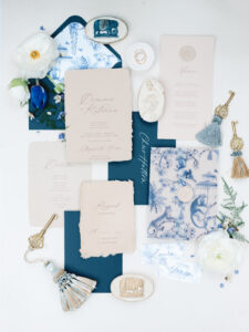 a blue and cream wedding invitation suite flatlay