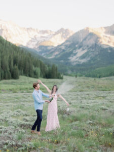 an engagement photoshoot in the mountains with a bottle of champagne 