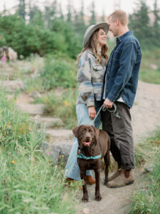 a couple on their engagement photoshoot in the mountains with their brown dog