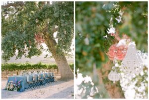 a blue wedding reception table under a tree with chandeliers in the trees