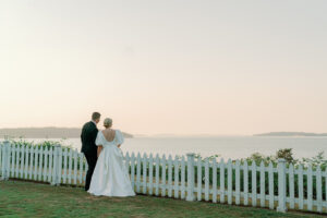 a bride and groom looking at the sunset over the ocean in port gamble wedding in washington