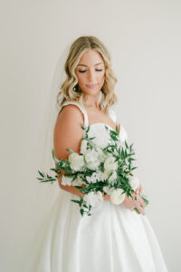 a utah bride looking down at her wedding bouquet