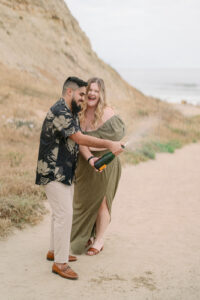 a couple spraying champagne at their torrey pines engagement session