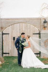 a bride and groom facing each other with a wooden doorway behind them at their wedding in utah