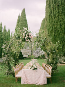 a wedding table luxuriously decorated with chandeliers amd florals for an elopement in italy at villa cetinale in tuscany