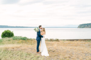 a groom kissing his bride on the forehead after their wedding at chambers bay in tacoma