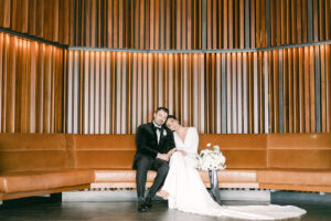 a bride and groom sitting on a wooden bench at the four seasons hotel in seattle for their wedding photos