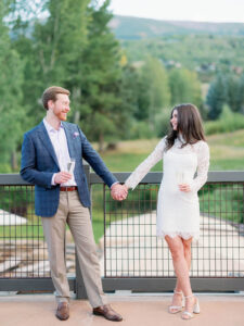 a couple holding hands and looking at each other with drinks in their hand