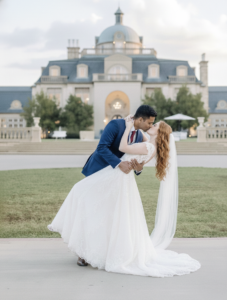 a couple kissing in front of the olana wedding venue in texas