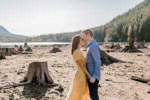 a couple about to kiss standing on sand at rattlesnake lake for their engagement session
