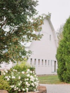 a white barn with trees and white floral bishes on an overcast day at this snohomish wedding venues in washington