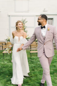 a bride and groom smiling and holding hands at their wedding at a barn in snohomish washington