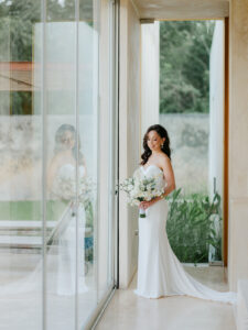 a bride in a modern styled home looking down at her florals at her elopement in yucatan mexico
