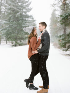 a couple facing each other and laughing in the snow up at suncadia for their engagement session