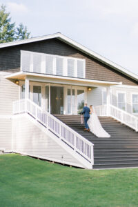 a bride and groom walking up wooden stairs into a building where they will be signing their marriage license