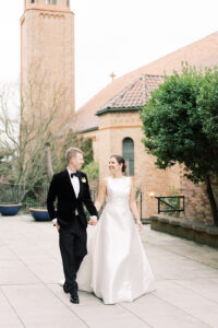 a bride and groom walking outside a church in seattle 