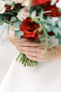 a bride holding her wedding bouquet and showing her wedding ring