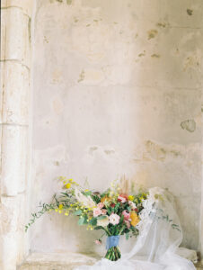 a wedding bouquet against an old wall at this santa barbara courthouse wedding