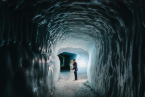 a bride and groom facing each other in an ice cave in iceland for their best elopement destinations