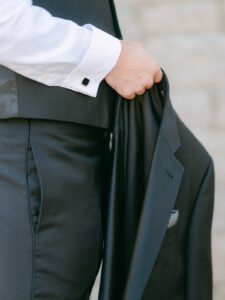 a groom holding his suit jacket at his wedding at the mount