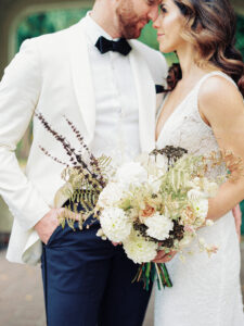 a bride and groom standing together with their foreheads touching.