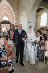 a father giving away his daughter at an old church wedding in champagne france