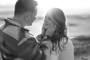 black and white photo of a couple about to kiss at their engagement session at saltair in utah