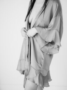 a black and white image of a woman wearing a silky robe for a boudoir photography outfits guide