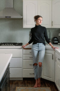a woman standing in a kitchen looking out the window