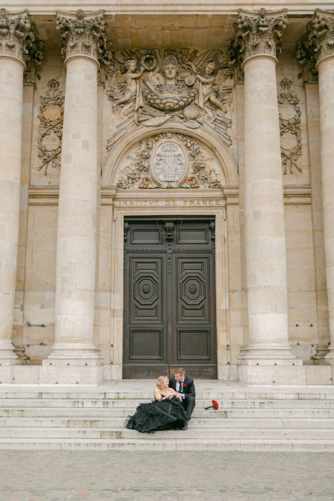 bride and groom sitting on steps in Paris before their wedding