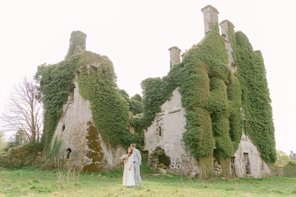bride and groom standing and cuddling with each other at Menlo Castle in Ireland