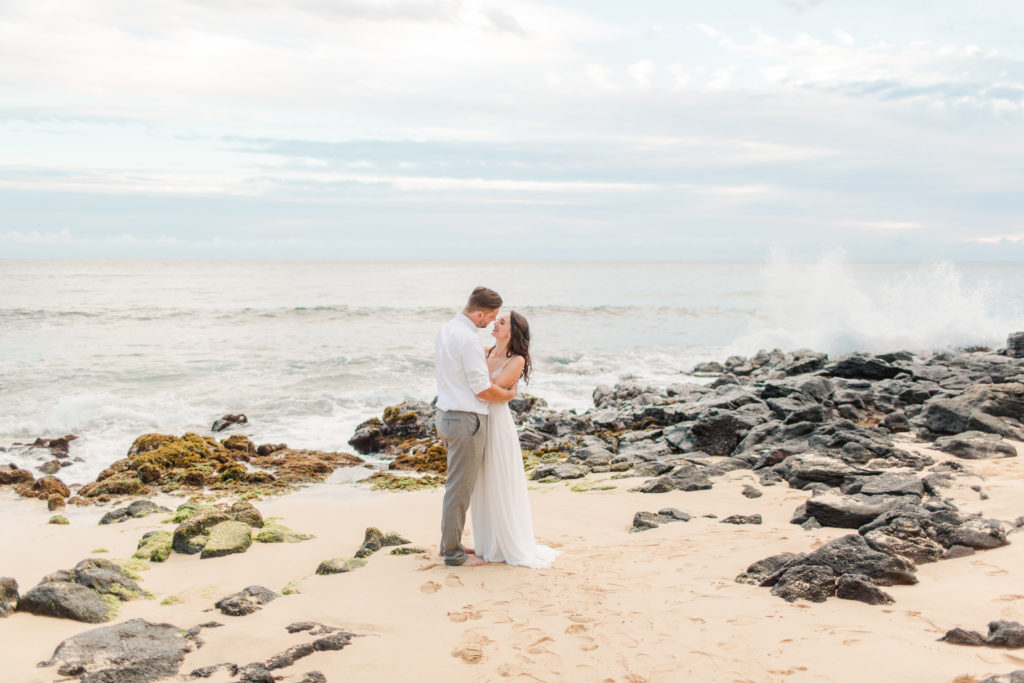 bride and groom standing on a beach in Kauai for their wedding photos