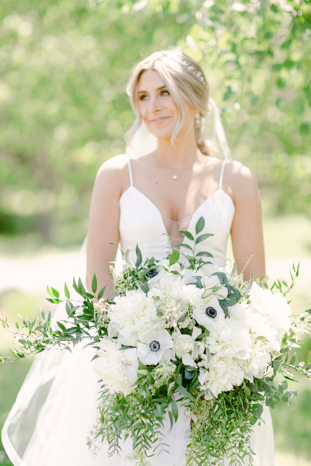 a bride with a floral bouquet looking away from the camera at her wedding in swiftwater cellars