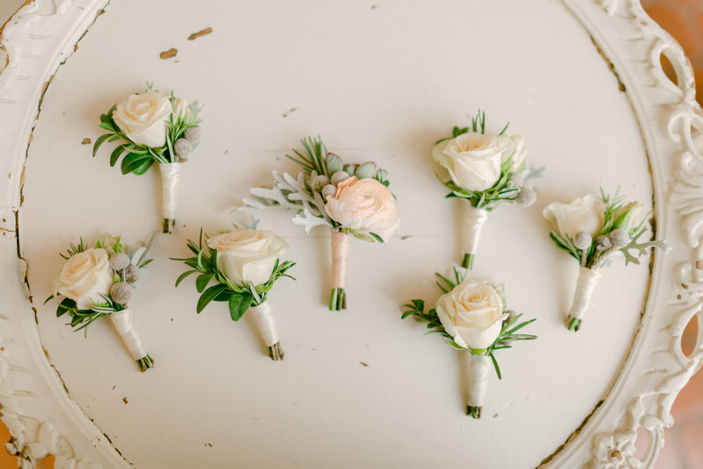 wedding boutonnière florals on a cream colored platter