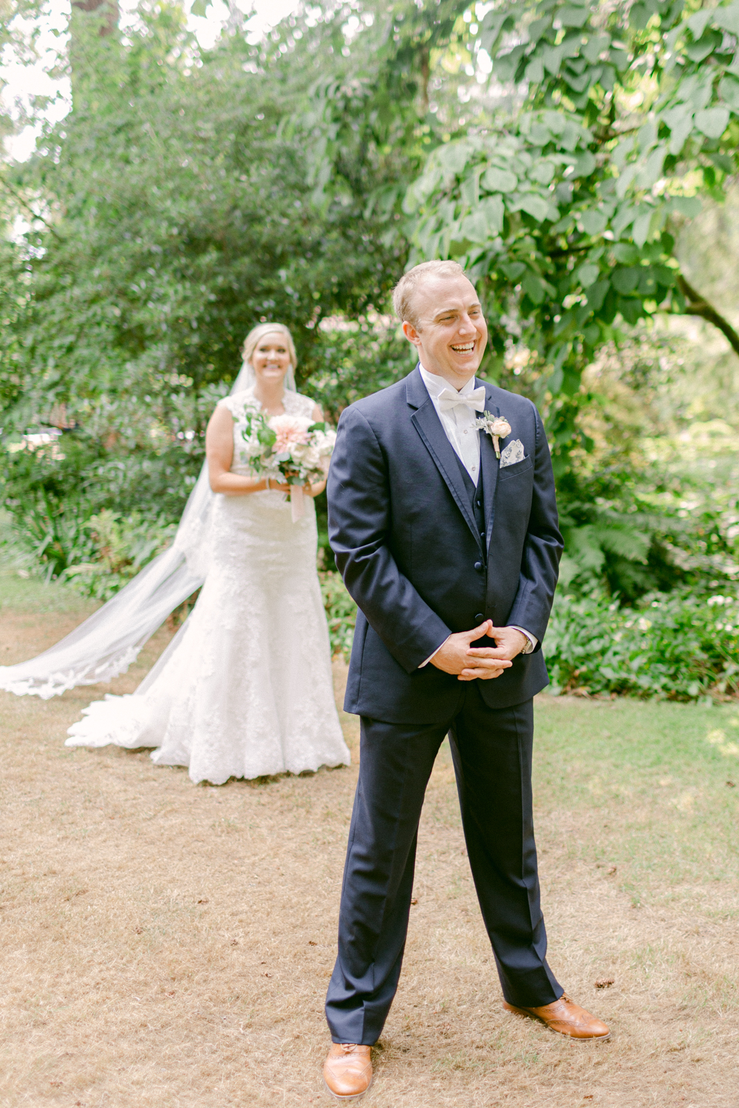a bride walking up to the groom from behind at lakewold gardens in washington to do their first look photos